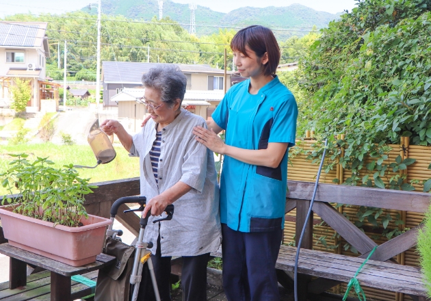 画像：植木の世話をする入居者