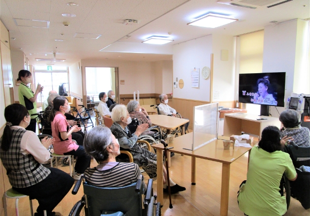 画像：談話室でテレビをみる入居者